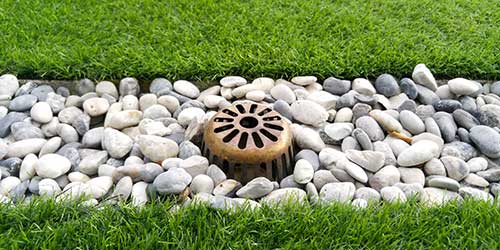 Designing residential and commercial drainage systems to fix low spots and gutter erosion in lawns and flower beds.